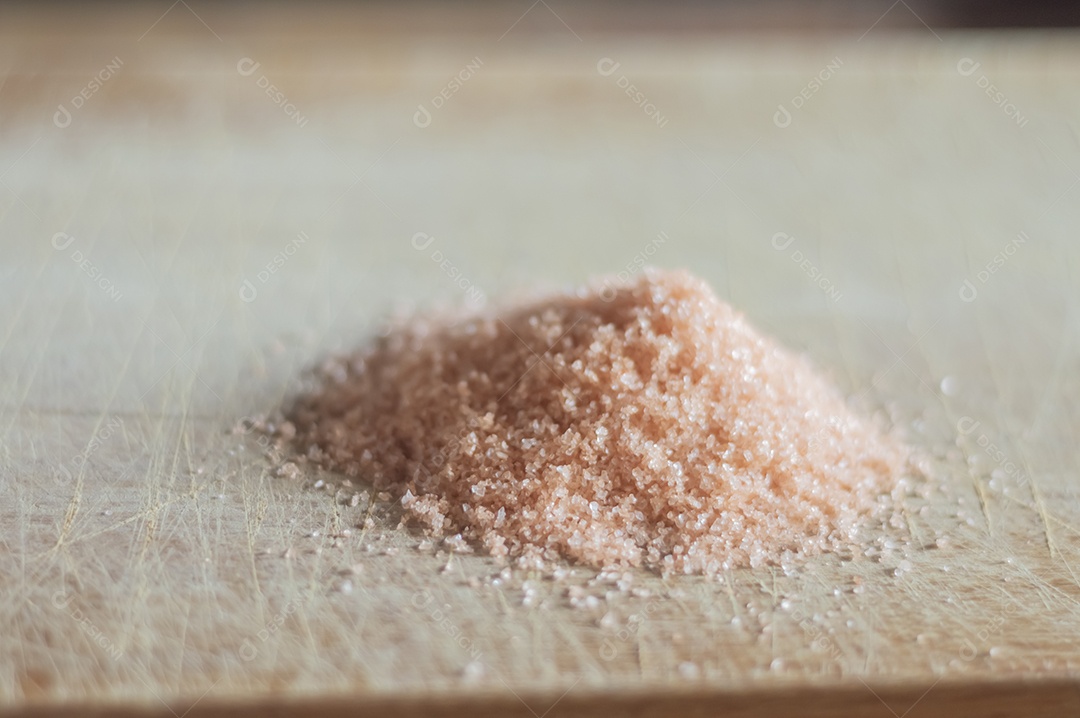 Sal do Himalaia em uma tábua de madeira com luz natural, sal vermelho.