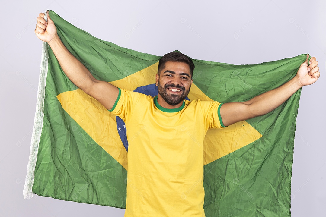 Homem jovem com camisa amarela e bandeira do Brasil