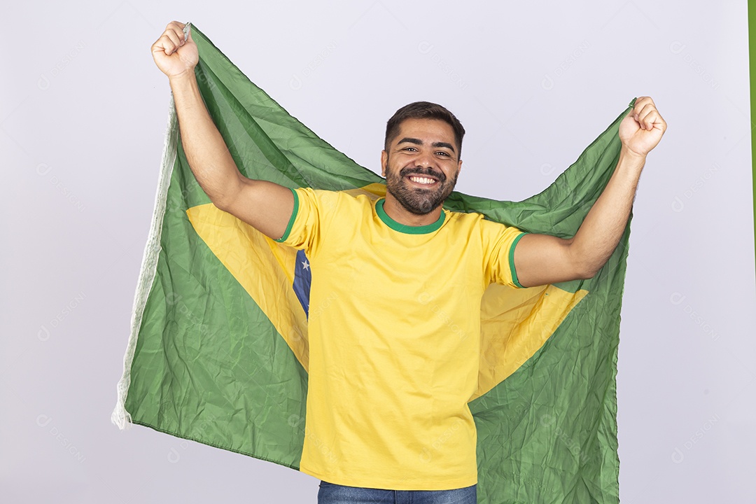 Homem jovem com camisa amarela e bandeira do Brasil