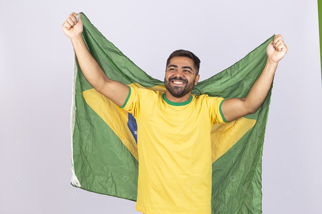 Homem jovem com camisa amarela e bandeira do Brasil