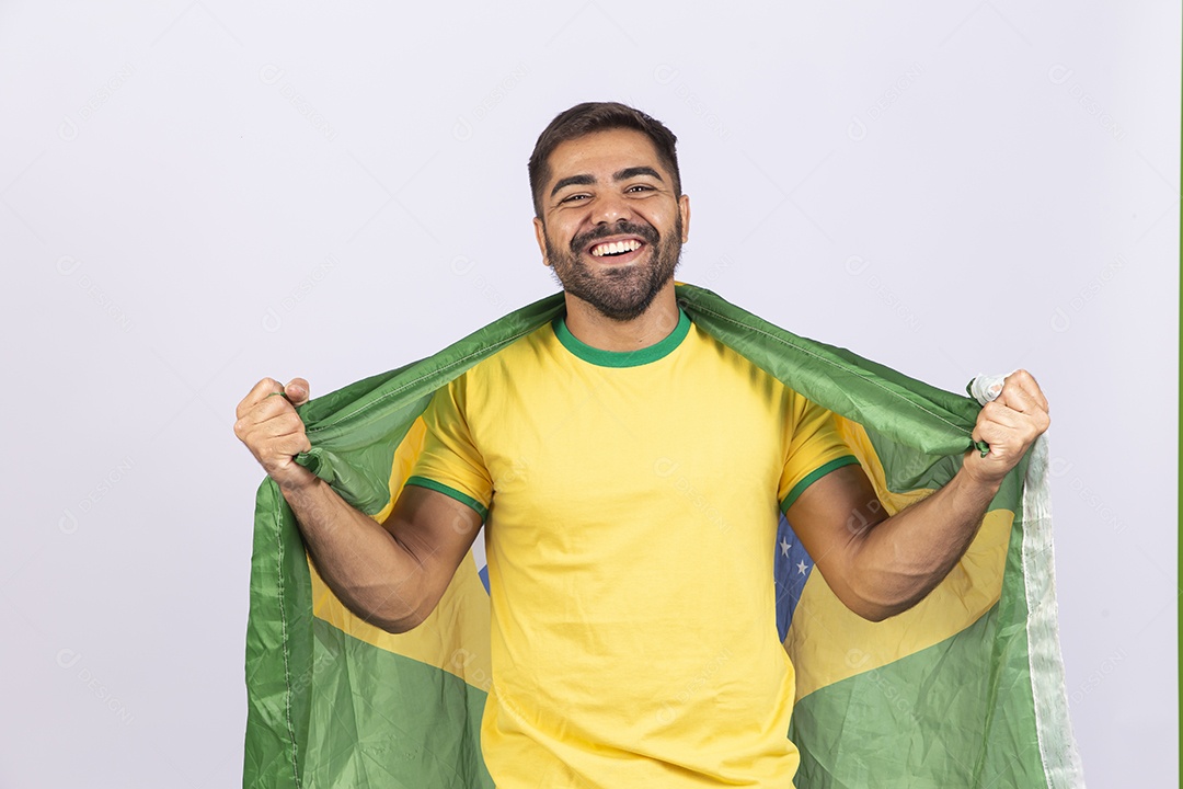 Homem jovem com camisa amarela e bandeira do Brasil