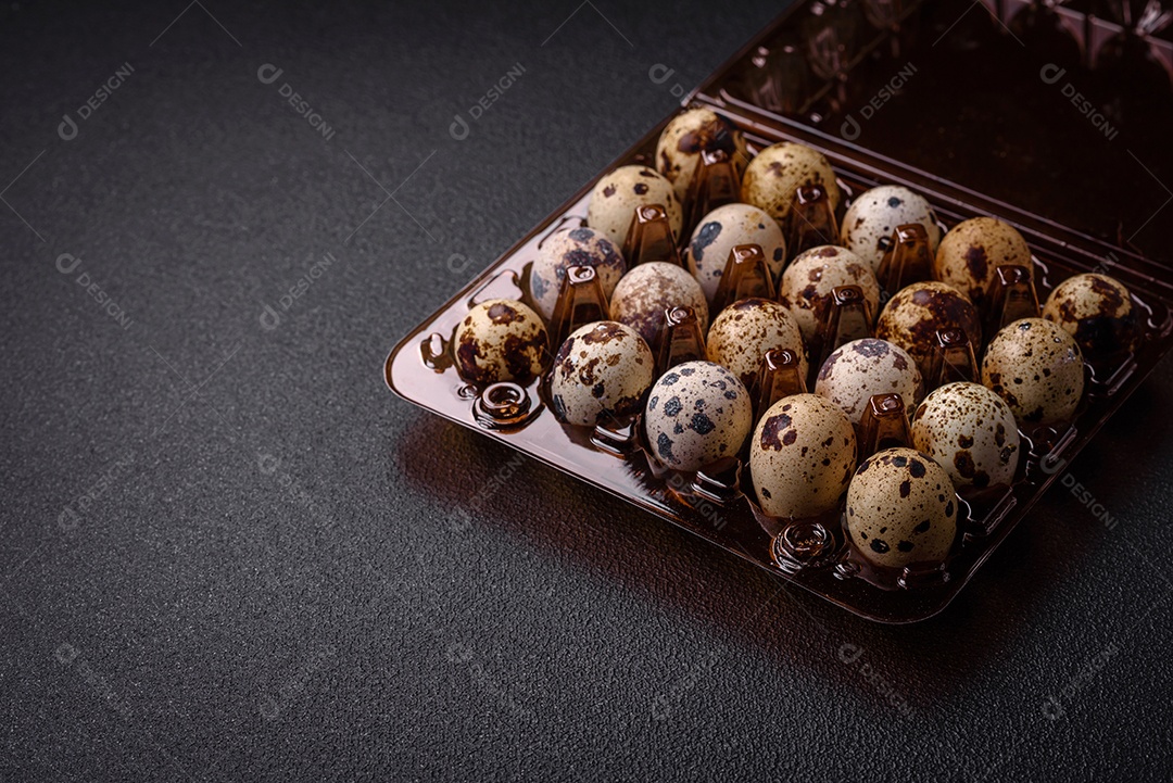 Ovos de codorna crus em uma caixa de plástico sobre um fundo escuro de concreto. Preparando um café da manhã nutritivo