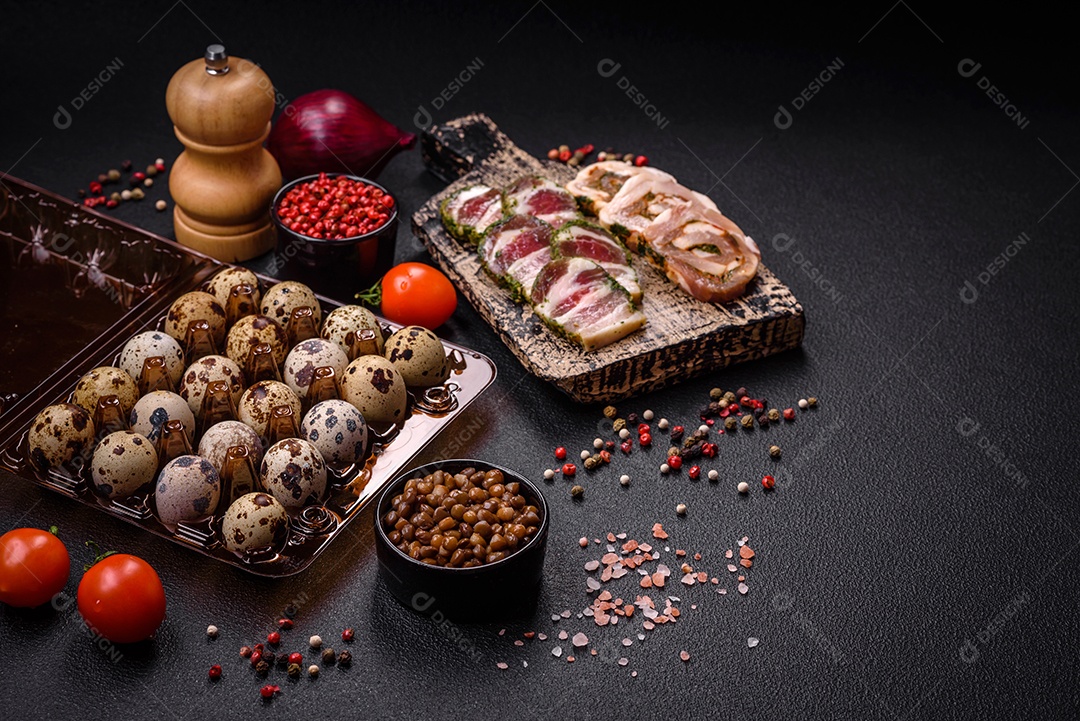 Ovos de codorna crus em uma caixa de plástico sobre um fundo escuro de concreto.