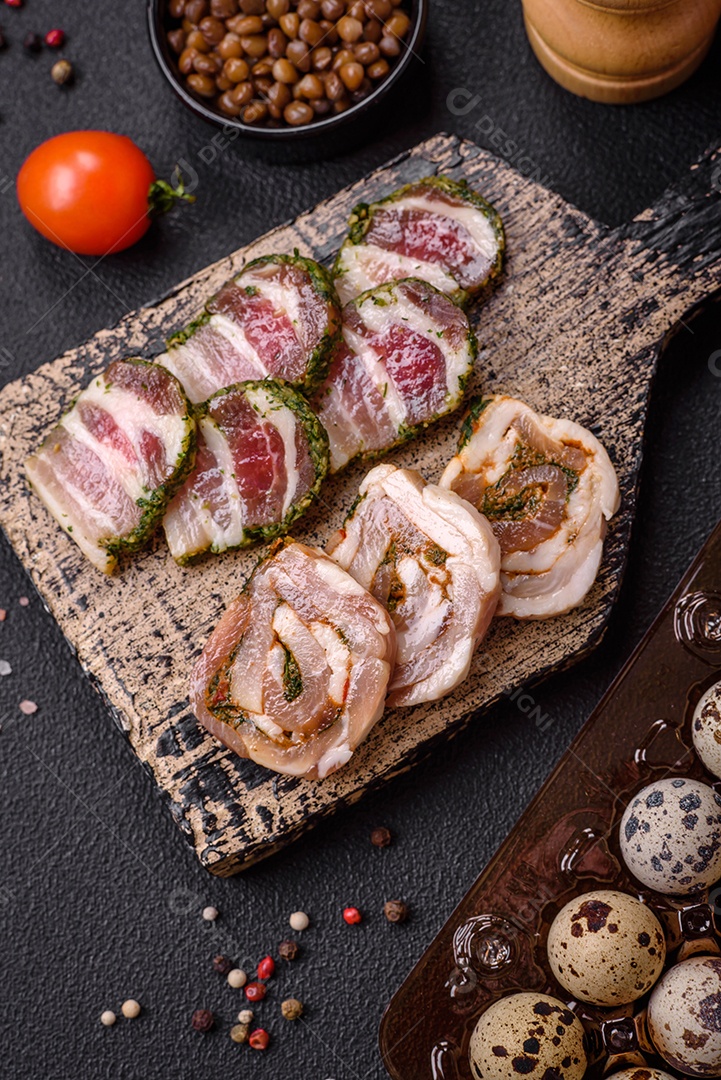 Ovos de codorna crus em uma caixa de plástico sobre um fundo escuro de concreto.