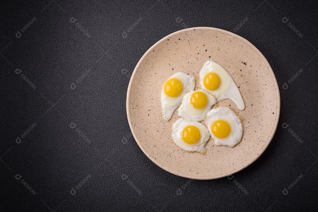 Delicioso café da manhã nutritivo com ovos de codorna fritos, bacon, legumes e tomate cereja com sal, especiarias