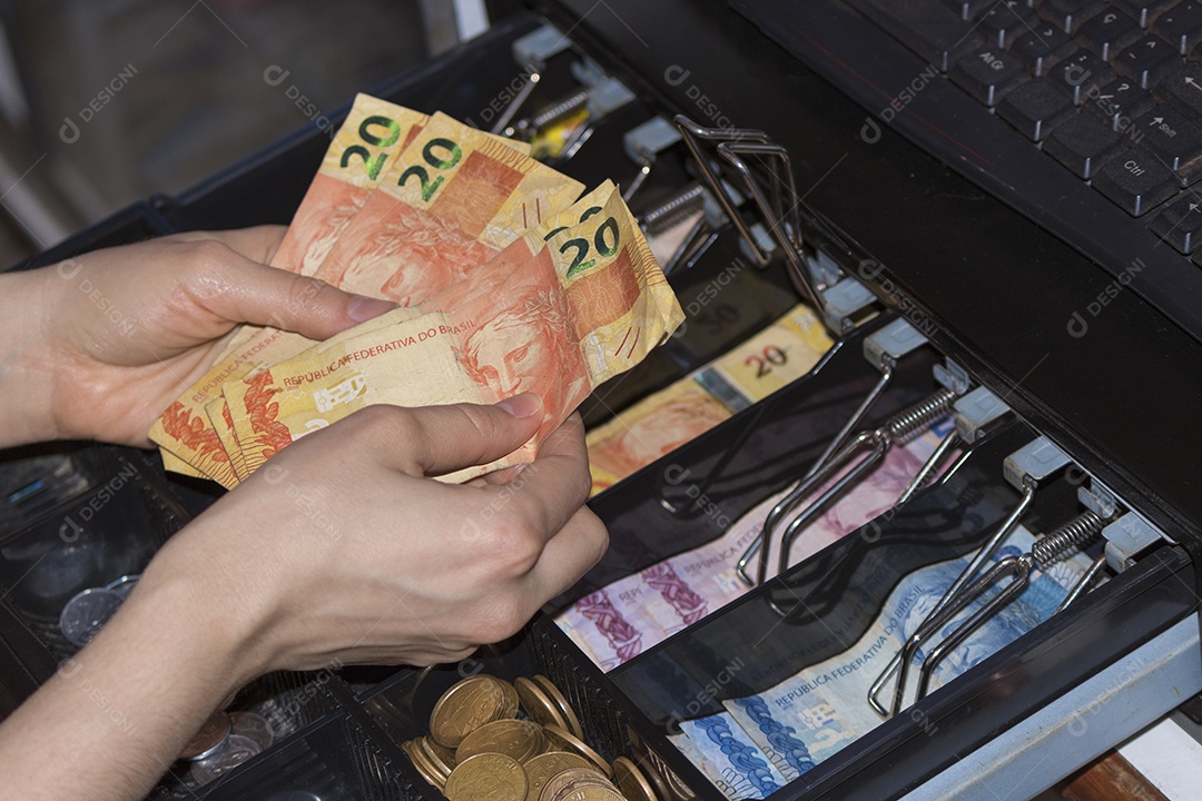 Notas e moedas brasileiras dentro do caixa eletrônico
