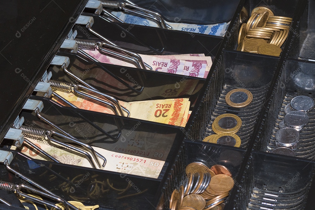 Notas e moedas brasileiras dentro do caixa eletrônico