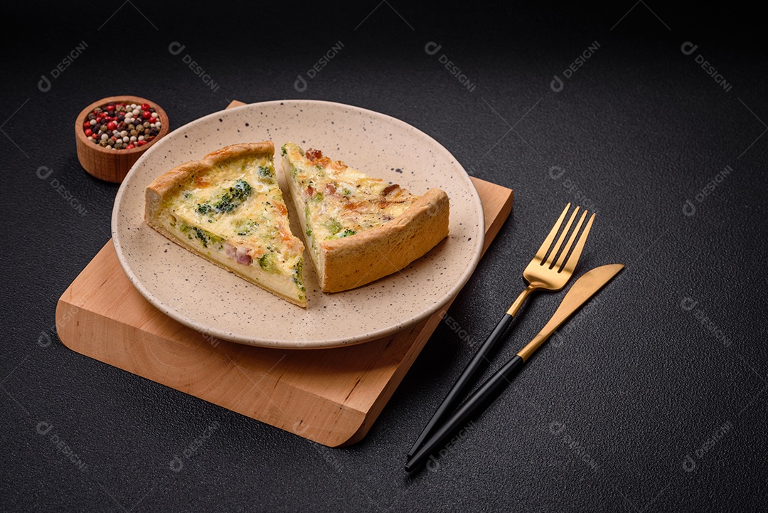 Deliciosa quiche com brócolis, queijo, frango, especiarias e ervas sobre um fundo escuro de concreto