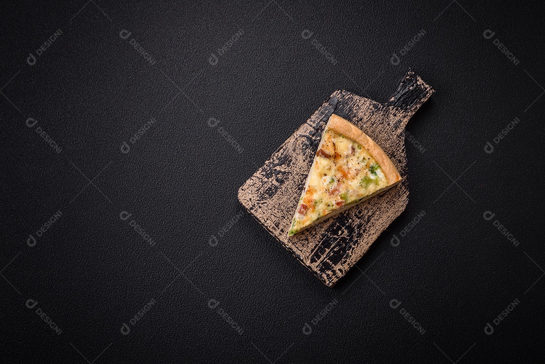 Deliciosa quiche com brócolis, queijo, frango, especiarias e ervas sobre um fundo escuro de concreto