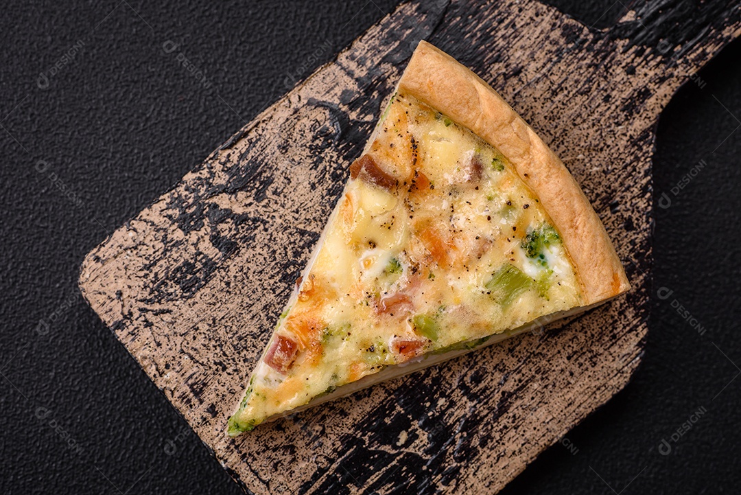 Deliciosa quiche com brócolis, queijo, frango, especiarias e ervas sobre um fundo escuro de concreto