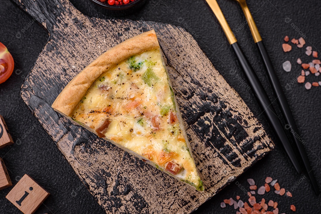 Deliciosa quiche com brócolis, queijo, frango, especiarias e ervas sobre um fundo escuro de concreto