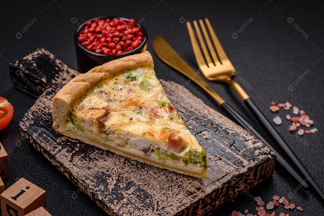 Deliciosa quiche com brócolis, queijo, frango, especiarias e ervas sobre um fundo escuro de concreto
