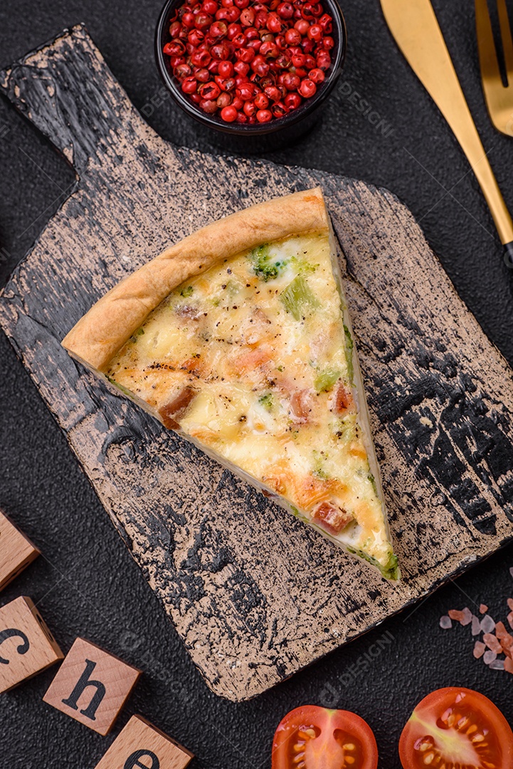 Deliciosa quiche com brócolis, queijo, frango, especiarias e ervas sobre um fundo escuro de concreto