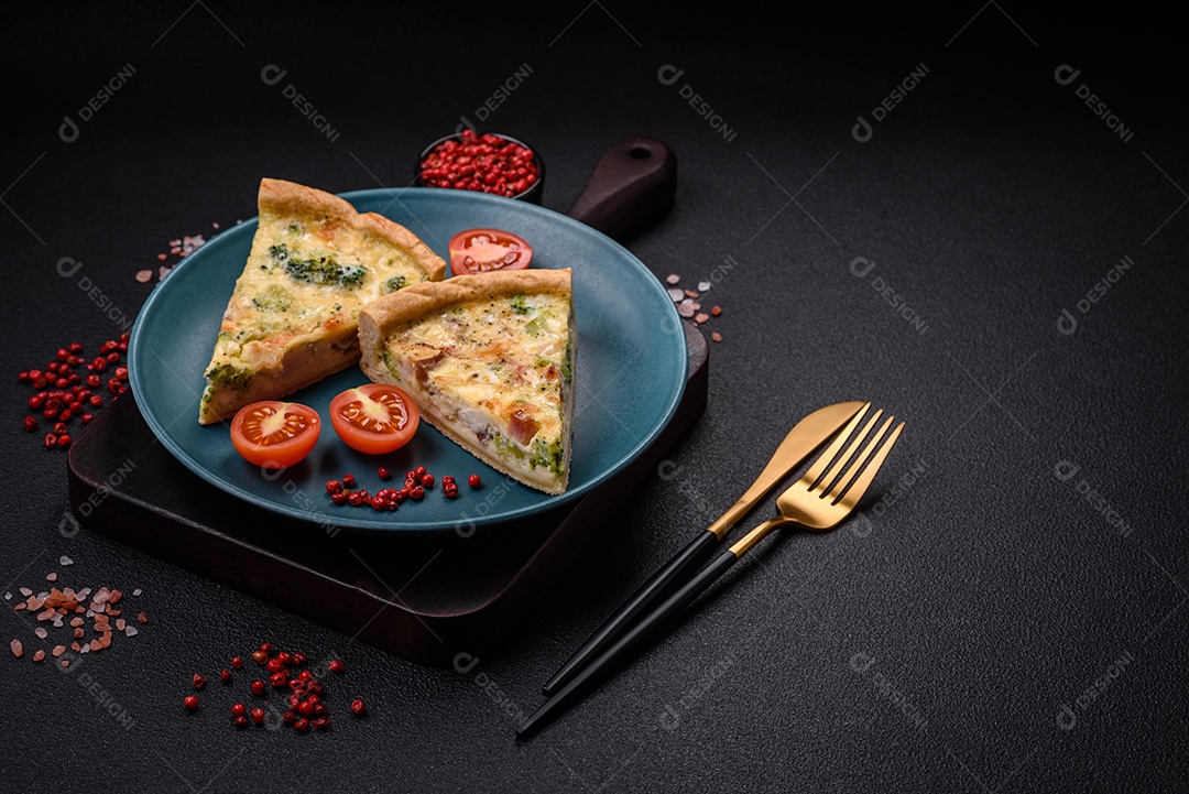 Deliciosa quiche com brócolis, queijo, frango, especiarias e ervas sobre um fundo escuro de concreto