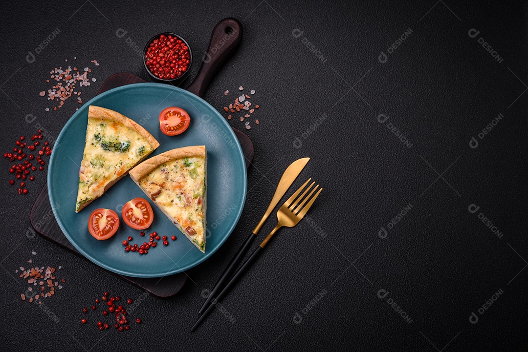 Deliciosa quiche com brócolis, queijo, frango, especiarias e ervas sobre um fundo escuro de concreto