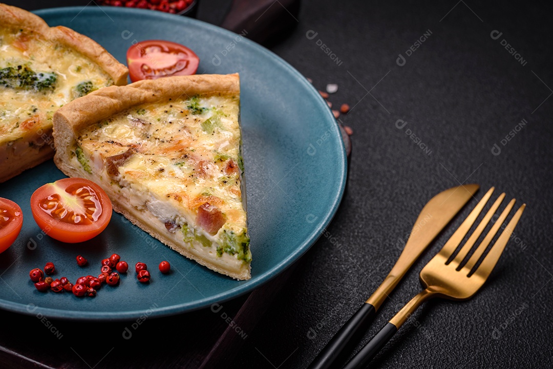 Deliciosa quiche com brócolis, queijo, frango, especiarias e ervas sobre um fundo escuro de concreto