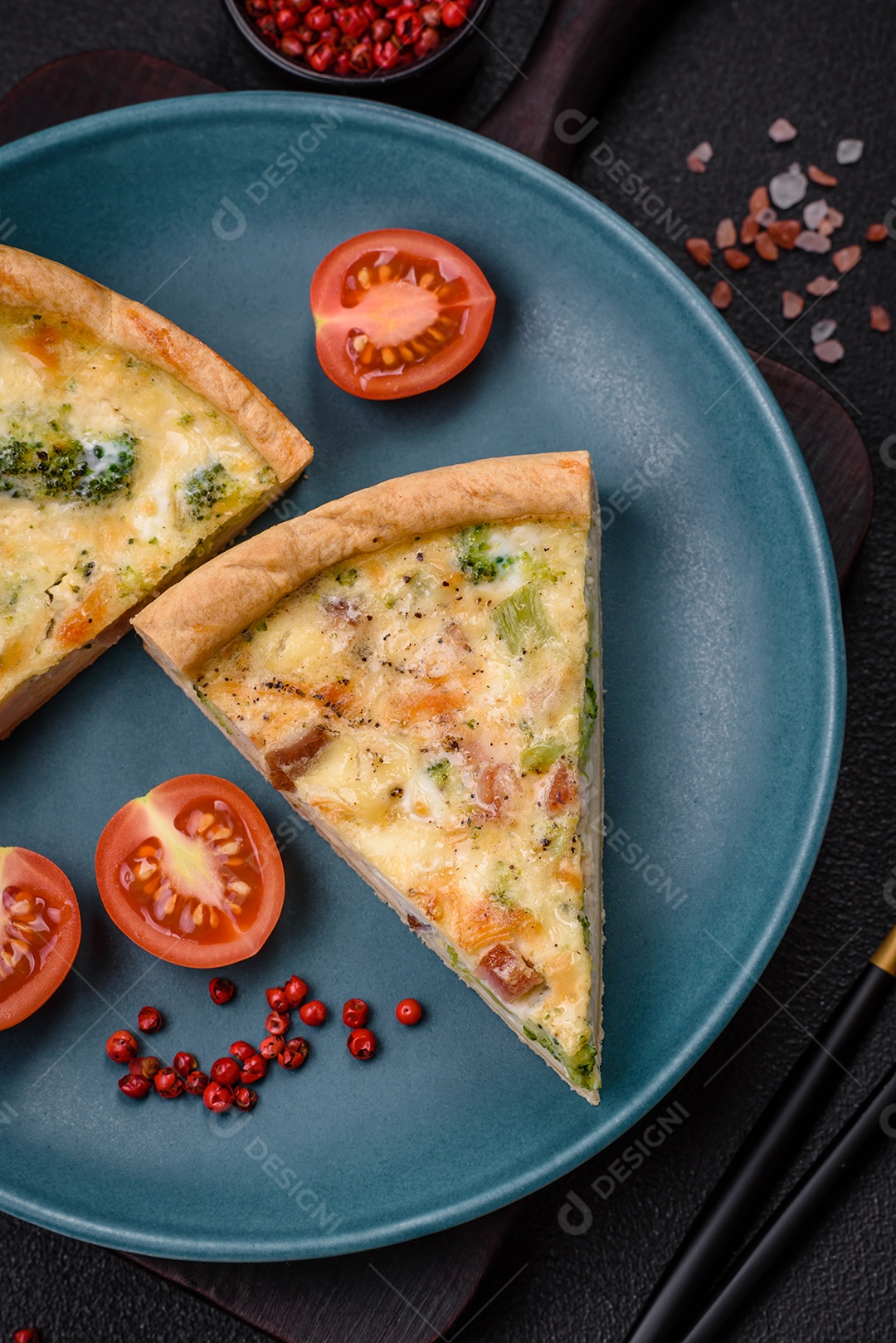 Deliciosa quiche com brócolis, queijo, frango, especiarias e ervas sobre um fundo escuro de concreto