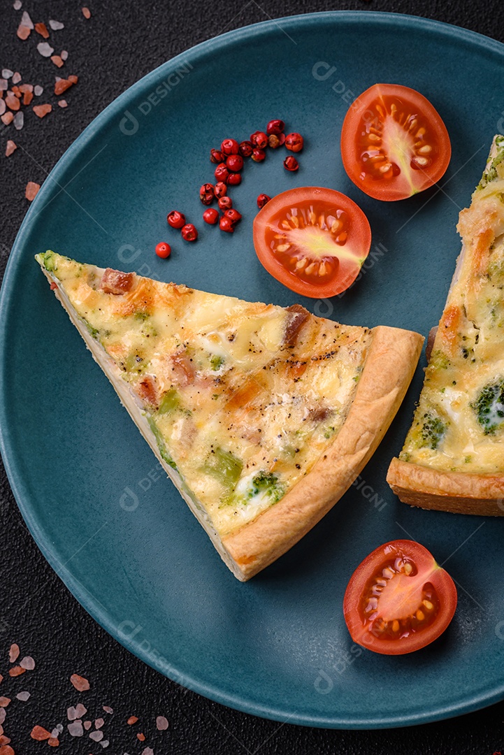 Deliciosa quiche com brócolis, queijo, frango, especiarias e ervas sobre um fundo escuro de concreto