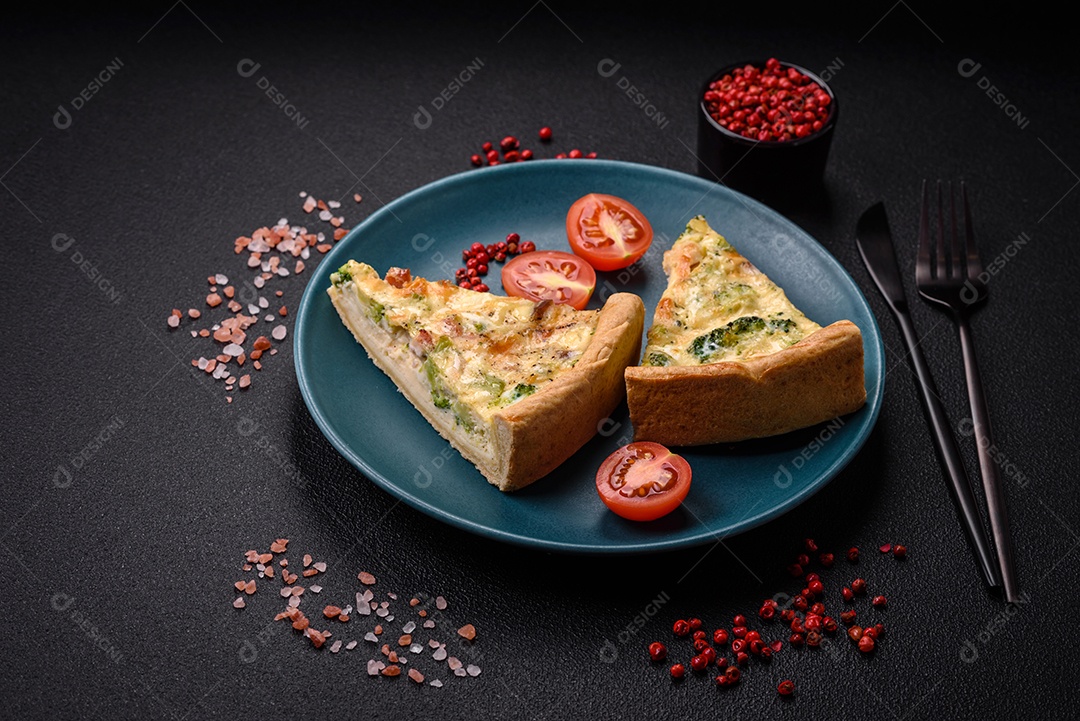 Deliciosa quiche com brócolis, queijo, frango, especiarias e ervas sobre um fundo escuro de concreto