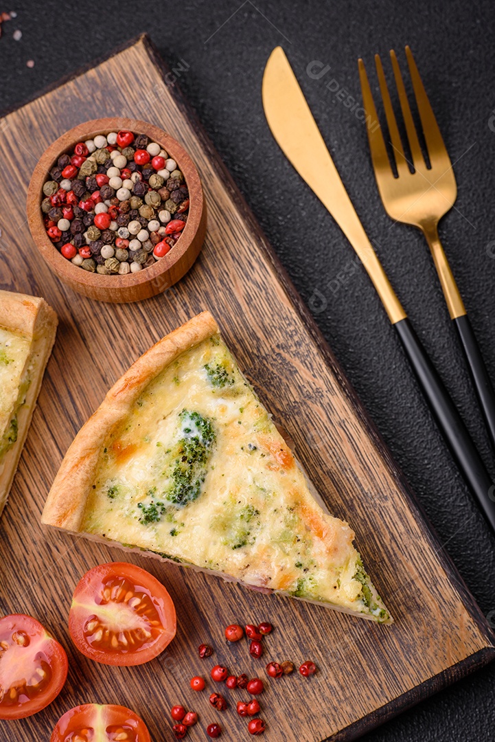 Deliciosa quiche com brócolis, queijo, frango, especiarias e ervas sobre um fundo escuro de concreto