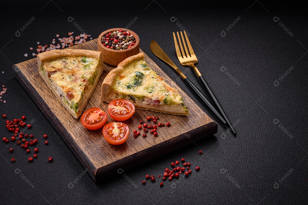 Deliciosa quiche com brócolis, queijo, frango, especiarias e ervas sobre um fundo escuro de concreto