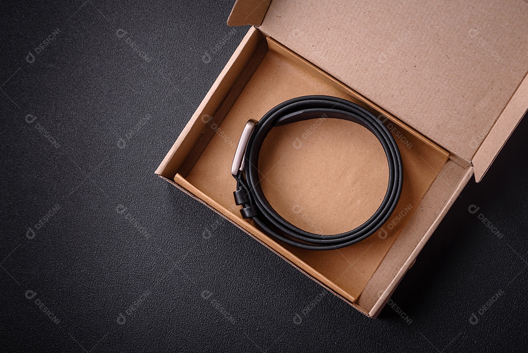 Novo cinto masculino de couro com fivela de metal à moda antiga sobre fundo escuro de concreto