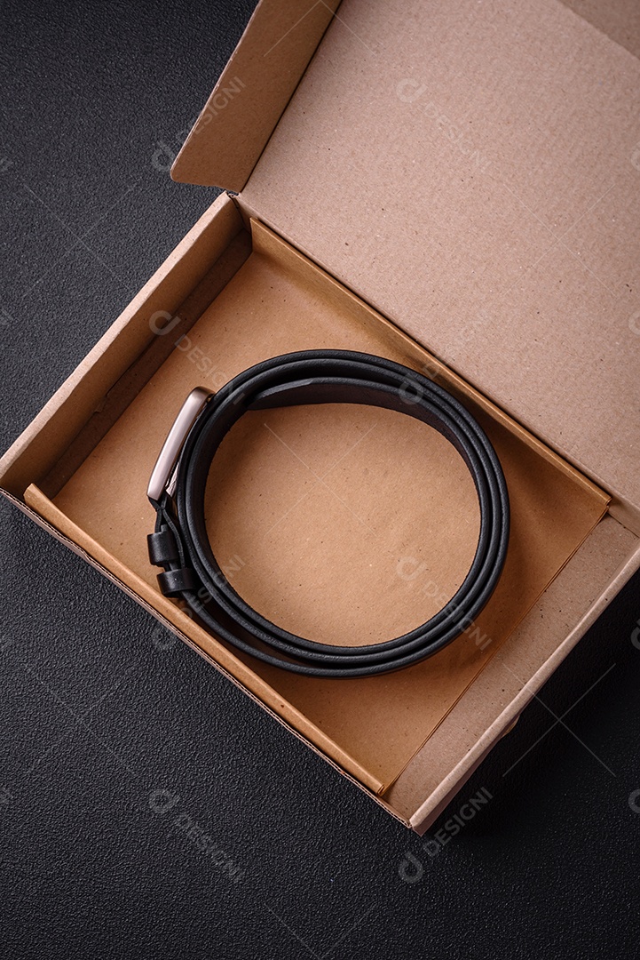 Novo cinto masculino de couro com fivela de metal à moda antiga sobre fundo escuro de concreto