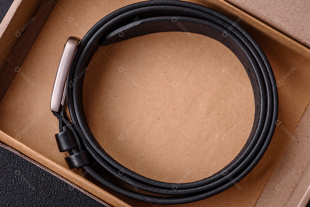 Novo cinto masculino de couro com fivela de metal à moda antiga sobre fundo escuro de concreto
