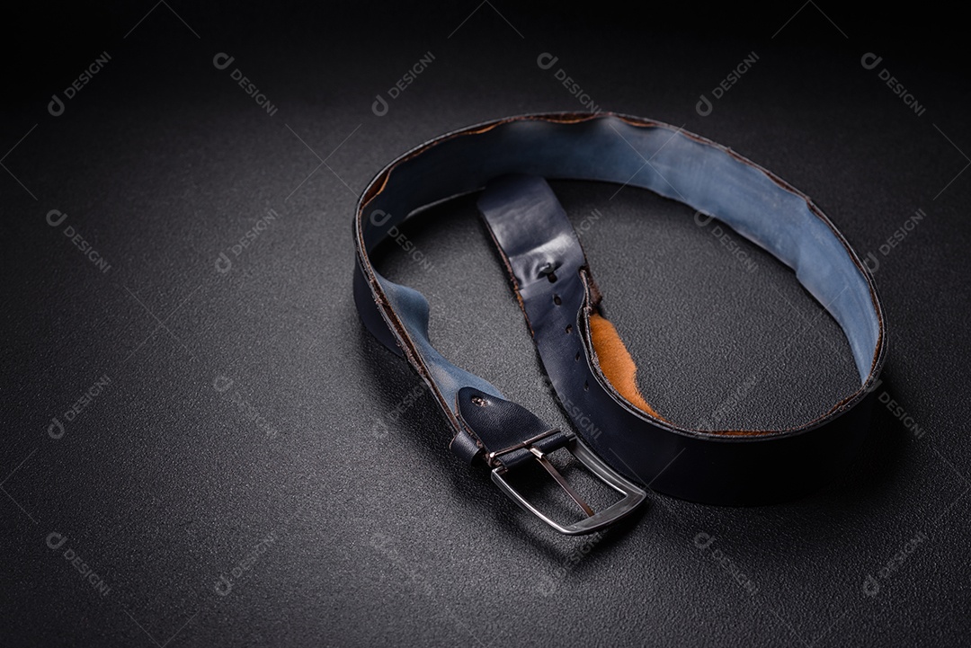Novo cinto masculino de couro com fivela de metal à moda antiga sobre fundo escuro de concreto