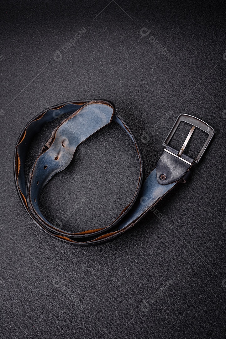 Cinto masculino de couro velho com fivela de metal à moda antiga sobre fundo escuro de concreto