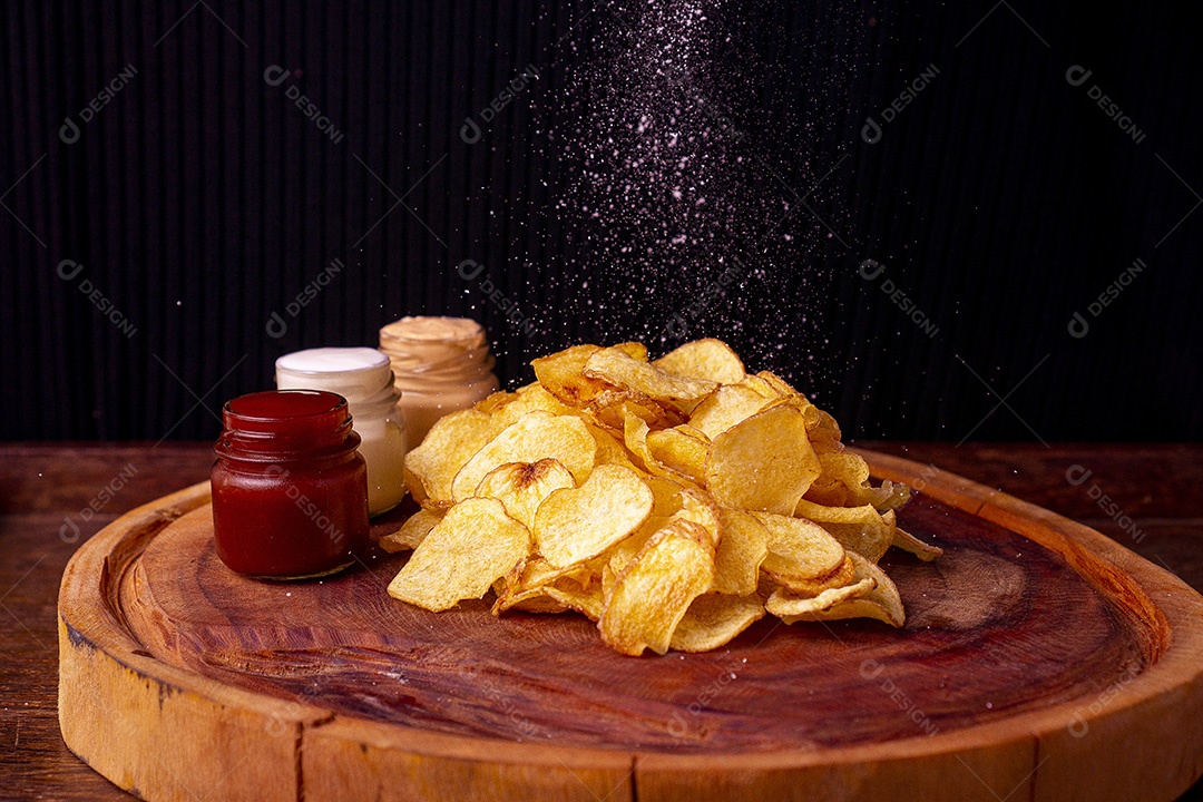 Deliciosas batatas chips sobre tábua de madeira