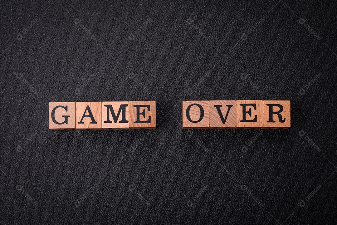 O jogo de inscrição acabou em cubos de madeira sobre um fundo escuro de concreto.