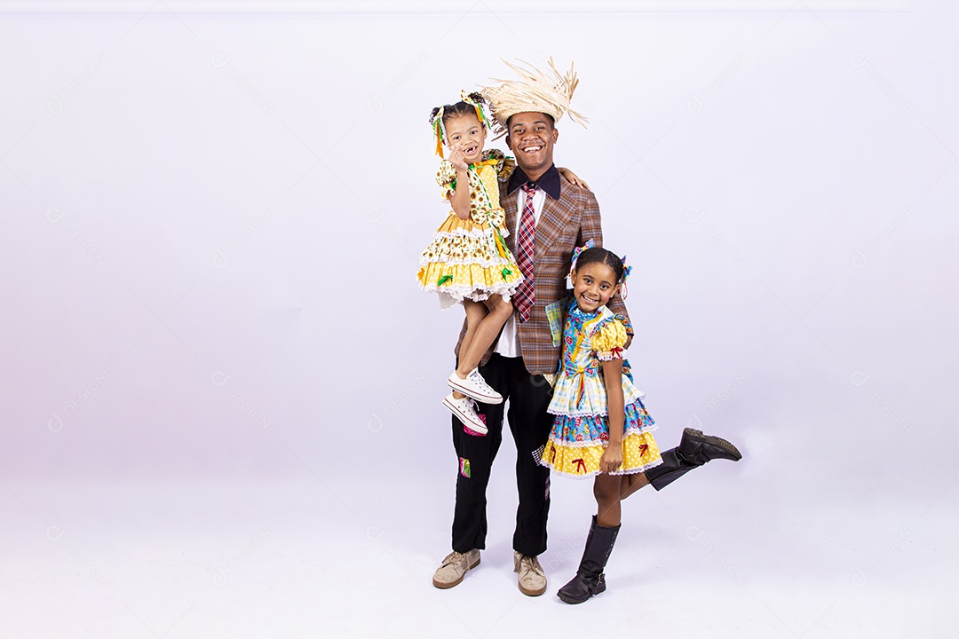 Pai ao lado de suas filhas felizes celebrando São João