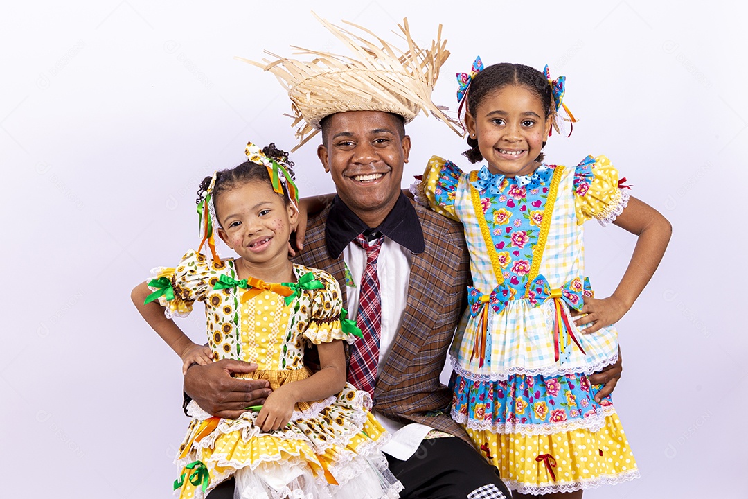 Pai ao lado de suas filhas felizes celebrando São João
