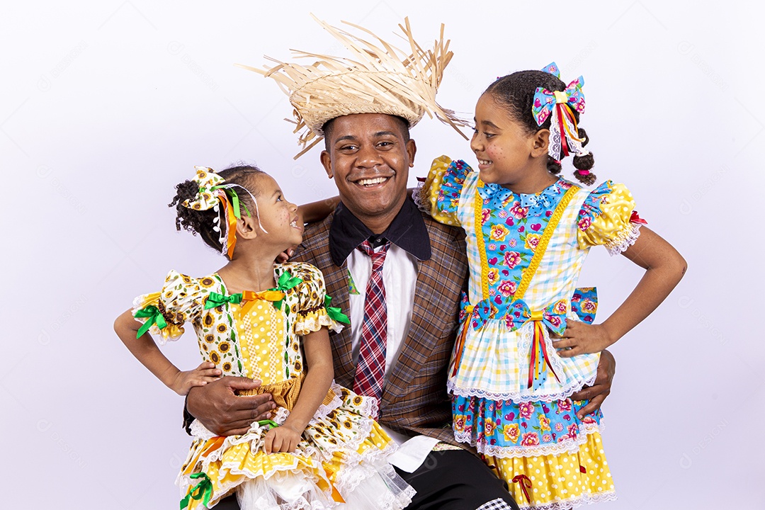 Pai ao lado de suas filhas felizes celebrando São João