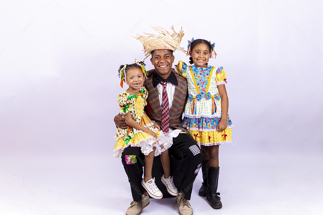 Pai ao lado de suas filhas felizes celebrando São João