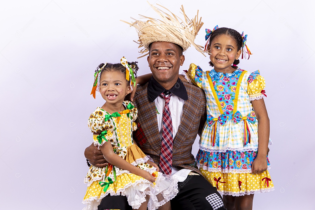 Pai ao lado de suas filhas felizes celebrando São João