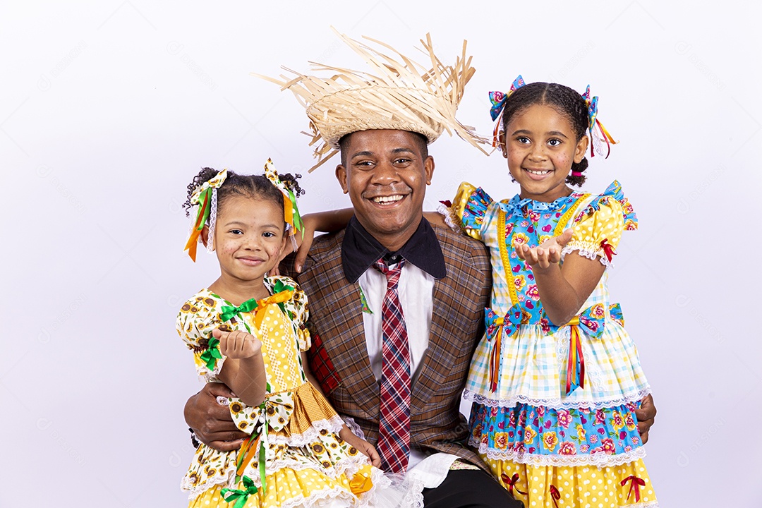 Pai ao lado de suas filhas felizes celebrando São João