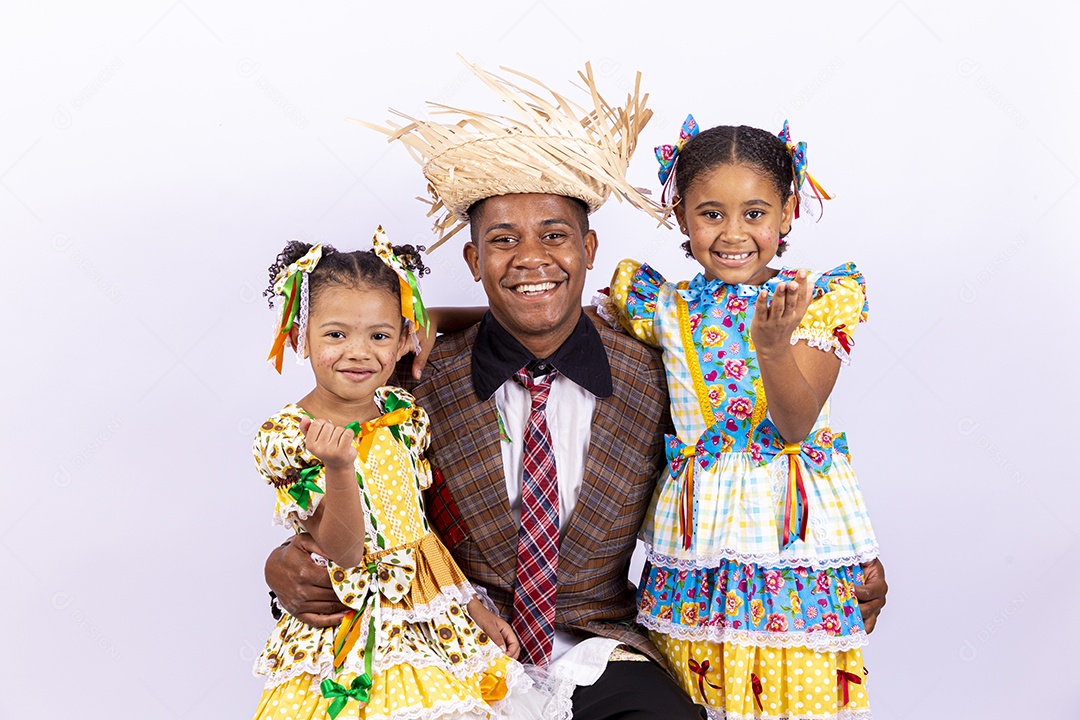 Pai ao lado de suas filhas felizes celebrando São João