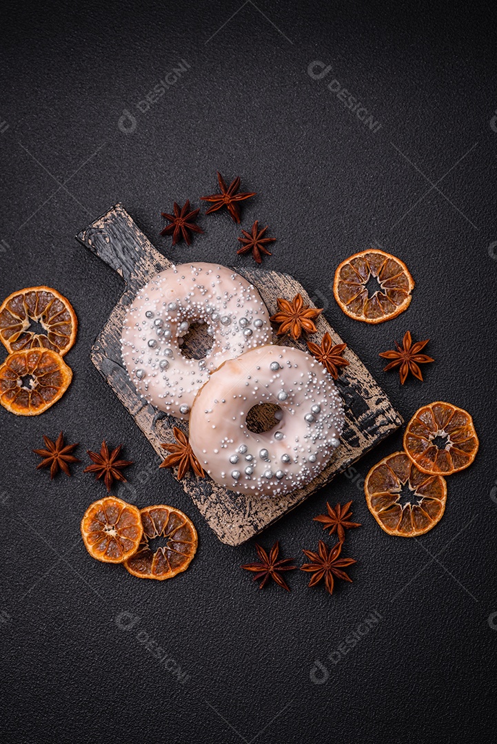Delicioso donut fresco de cor branca ou bege com contas prateadas e creme sobre um fundo escuro de concreto
