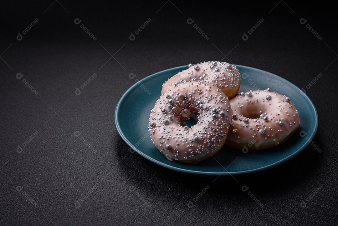 Delicioso donut fresco de cor branca ou bege com contas prateadas e creme sobre um fundo escuro de concreto