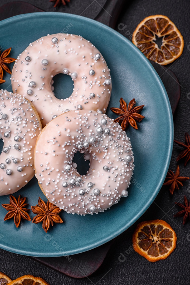 Delicioso donut fresco de cor branca ou bege com contas prateadas e creme sobre um fundo escuro de concreto