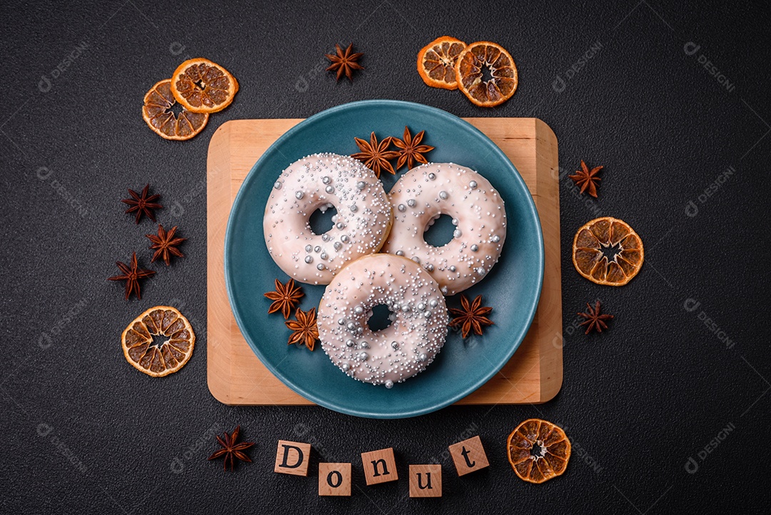 Delicioso donut fresco de cor branca ou bege com contas prateadas e creme sobre um fundo escuro de concreto
