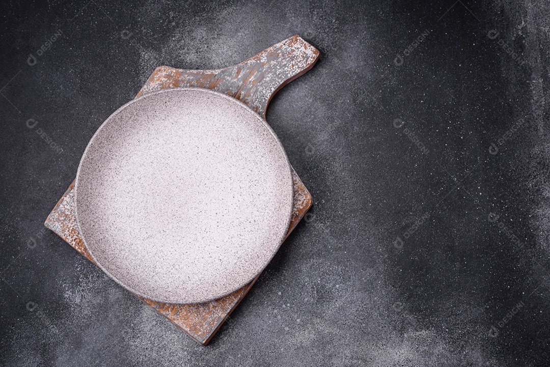 Placa cerâmica redonda vazia como um item de utensílios de cozinha sobre um fundo de concreto texturizado