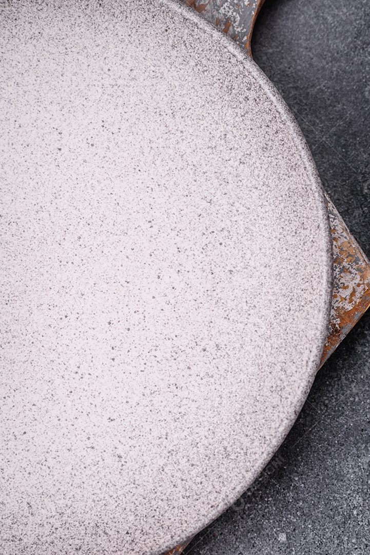 Placa cerâmica redonda vazia como um item de utensílios de cozinha sobre um fundo de concreto texturizado