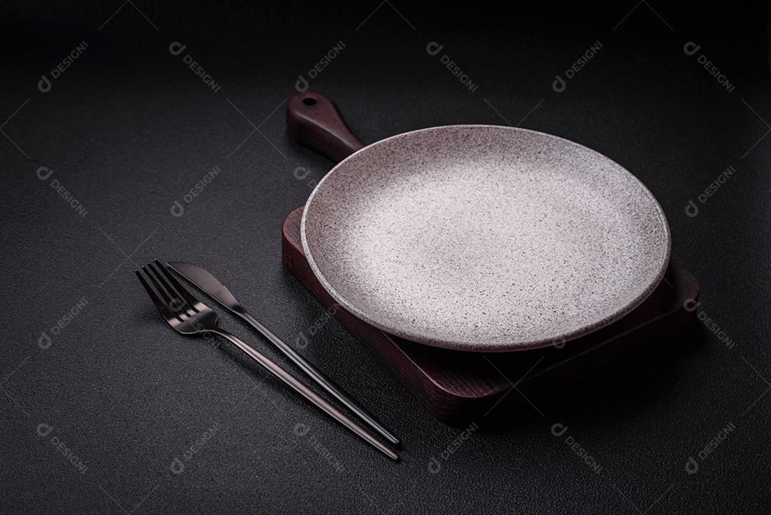 Placa cerâmica redonda vazia como um item de utensílios de cozinha sobre um fundo de concreto texturizado