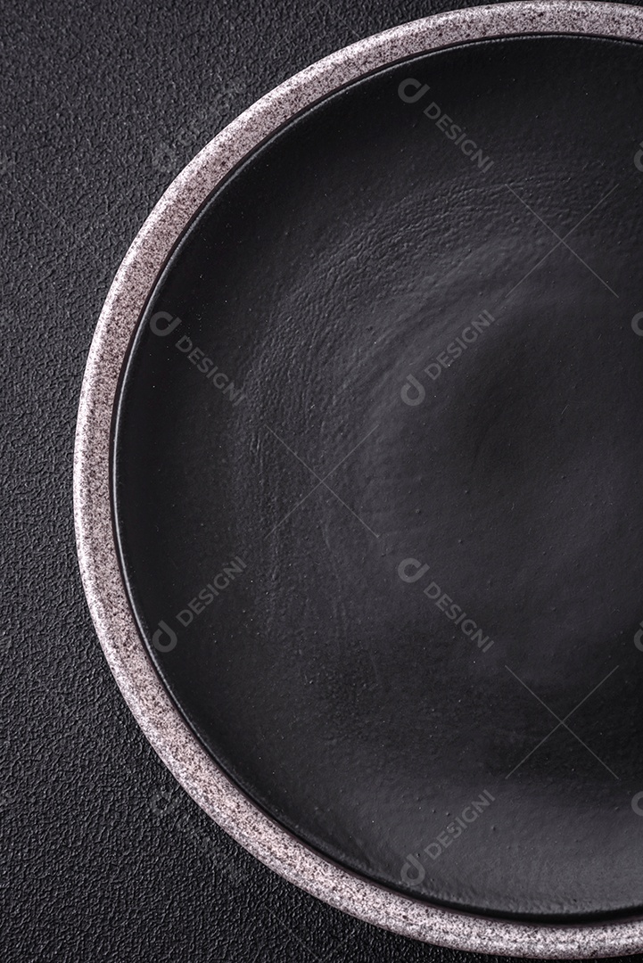 Placa cerâmica redonda vazia como um item de utensílios de cozinha sobre um fundo de concreto texturizado