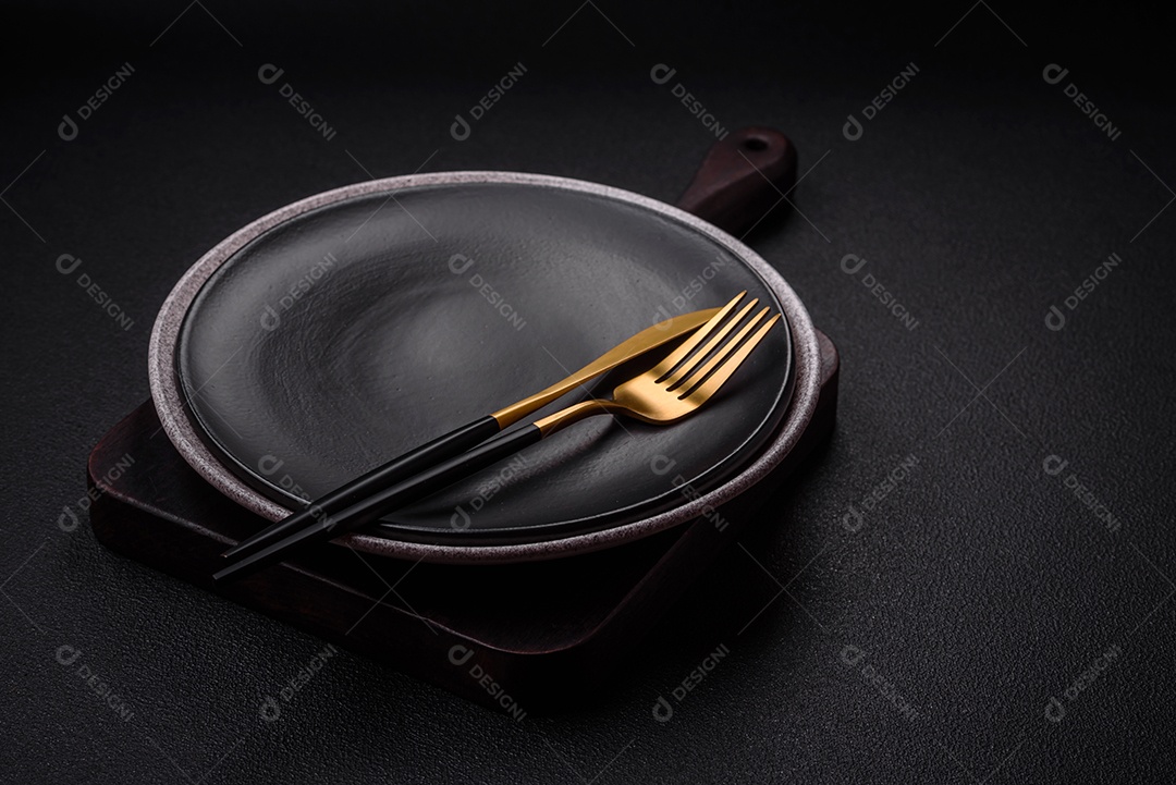 Placa cerâmica redonda vazia como um item de utensílios de cozinha sobre um fundo de concreto texturizado