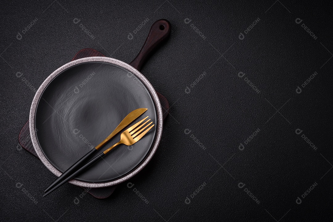 Placa cerâmica redonda vazia como um item de utensílios de cozinha sobre um fundo de concreto texturizado