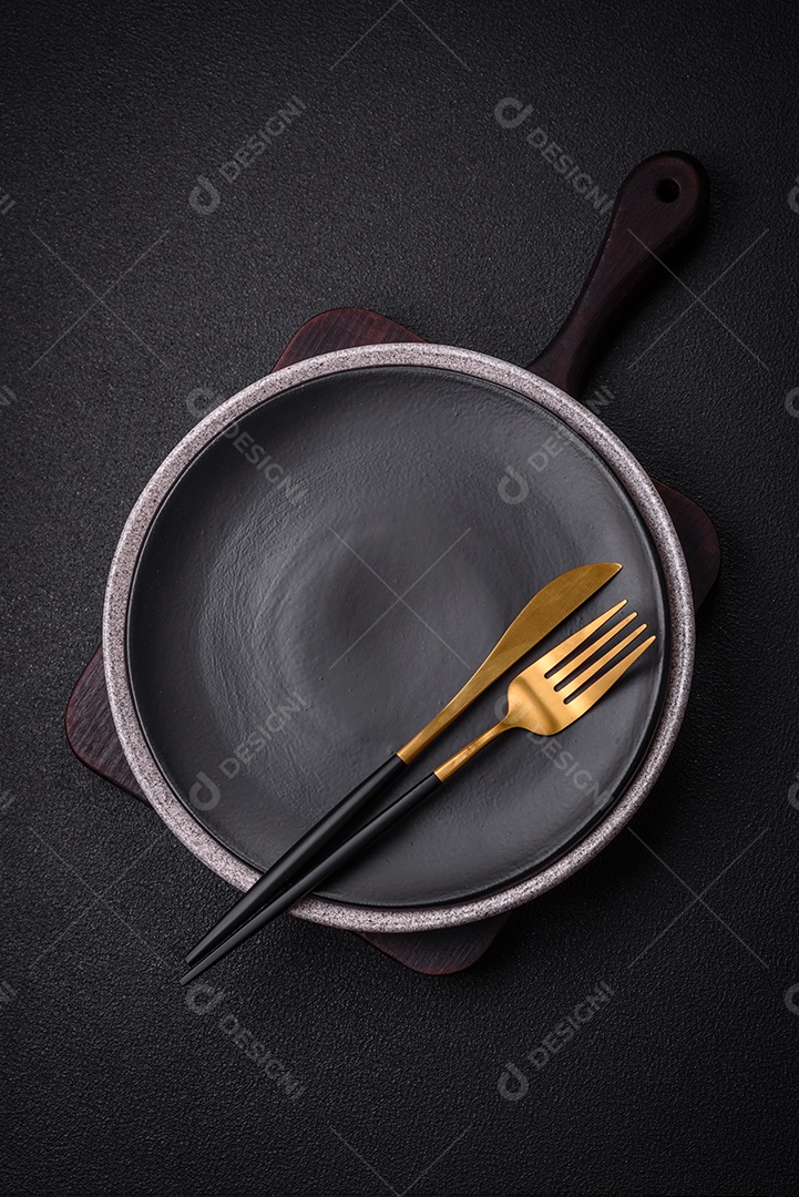 Placa cerâmica redonda vazia como um item de utensílios de cozinha sobre um fundo de concreto texturizado